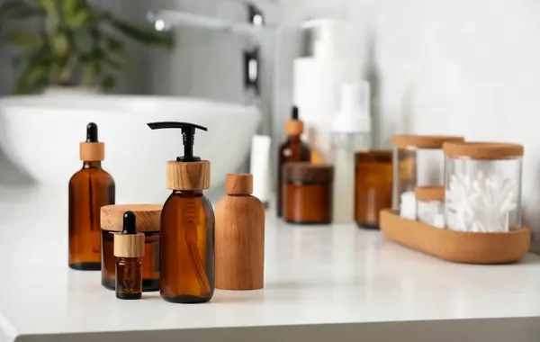 Frascos de cosméticos naturais em tom âmbar organizados em bancada de banheiro, sendo um exemplo claro de o que vender na shopee com baixo investimento