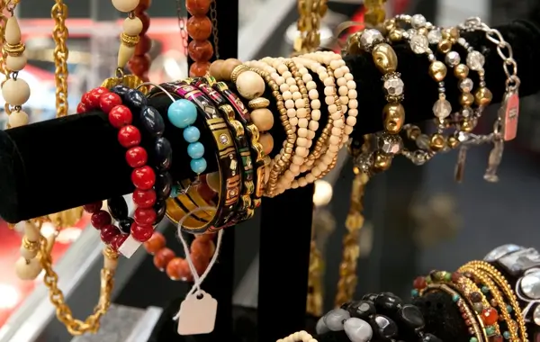 Pulseiras de bijuteria coloridas expostas em suporte de loja